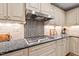 Gourmet kitchen features granite countertops, stainless hood, and travertine backsplash at 9900 Two Robins Ct, Raleigh, NC 27613
