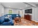 Bright living room showcasing a blue sectional, hardwood floors, and natural light at 9900 Two Robins Ct, Raleigh, NC 27613