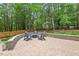 Scenic backyard with firepit and outdoor seating area surrounded by lush trees at 9900 Two Robins Ct, Raleigh, NC 27613