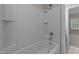 Clean, white bathtub and shower combination with tile surround, offering a refreshing bathing experience at 10 Stillwood Ct, Clayton, NC 27520