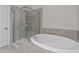 Bright bathroom featuring a shower with glass door and a soaking tub at 10 Stillwood Ct, Clayton, NC 27520