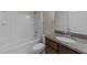 Well-lit bathroom with a tub-shower combo, dark wood vanity with granite countertop and tiled floors at 10 Stillwood Ct, Clayton, NC 27520