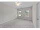 Inviting bedroom featuring plush carpet, two large windows, and a ceiling fan at 10 Stillwood Ct, Clayton, NC 27520