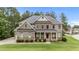Stately two-story brick home boasts a covered front porch and professionally landscaped yard at 10 Stillwood Ct, Clayton, NC 27520