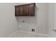 Practical laundry room with upper cabinets and utility connections for washer and dryer at 10 Stillwood Ct, Clayton, NC 27520