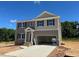 Two-story home showcasing a two-car garage and neutral color scheme against a clear blue sky at 100 Cordoba Dr, Franklinton, NC 27525