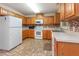 Functional kitchen featuring tile backsplash, white appliances, and plenty of wood cabinet storage at 1000 Strobus Ct, Wendell, NC 27591