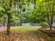 Grassy backyard with a gray wooden fence and various trees at 10317 Roadstead W Way, Raleigh, NC 27613