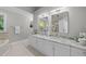 A bathroom features dual sinks, granite counters, vanity, tub, two mirrors, and two windows with natural light at 10317 Roadstead W Way, Raleigh, NC 27613