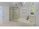 A bathroom features a corner tub with jets, a tiled shower, and a window with natural light at 10317 Roadstead W Way, Raleigh, NC 27613