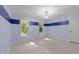 A blue bedroom features light wood floors, dark blue accent stripe, two windows with a view, and a modern light fixture at 10317 Roadstead W Way, Raleigh, NC 27613