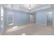 A blue bedroom features light wood floors, an open closet, and a modern ceiling fixture at 10317 Roadstead W Way, Raleigh, NC 27613