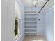 A blue walk-in closet features built-in shelving, light wood floors, a window, and a modern ceiling fixture at 10317 Roadstead W Way, Raleigh, NC 27613