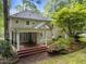 Backyard view of home with a covered porch, manicured landscaping, and mature trees at 10317 Roadstead W Way, Raleigh, NC 27613