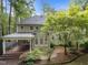 Backyard view of home with a covered porch, manicured landscaping, and mature trees at 10317 Roadstead W Way, Raleigh, NC 27613