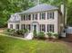 Beautiful two-story home with a blue front door and lush green lawn and professional landscaping at 10317 Roadstead W Way, Raleigh, NC 27613