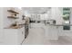 Bright kitchen features white cabinets, stainless appliances, granite counters, and wood open shelves at 10317 Roadstead W Way, Raleigh, NC 27613