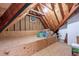 Spacious unfinished attic with exposed beams, plywood walls, and lighting at 104 Tutbury Pl, Cary, NC 27519