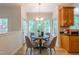 Bright eat-in dining area with hardwood floors, modern chandelier, and multiple windows at 104 Tutbury Pl, Cary, NC 27519