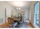 Elegant dining room with hardwood floors, a wooden table, and wainscoting at 104 Tutbury Pl, Cary, NC 27519