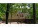 Back exterior view of home featuring a brick foundation, neutral siding, and wooded scenery at 104 Tutbury Pl, Cary, NC 27519