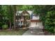 Two-story brick home featuring a two-car garage and manicured landscaping, set among mature trees at 104 Tutbury Pl, Cary, NC 27519