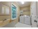 Laundry room with sink, washer, dryer, storage shelves, and natural light at 104 Tutbury Pl, Cary, NC 27519