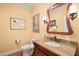 Charming powder room featuring a granite countertop vanity and decorative mirror at 10540 Byrum Woods Dr, Raleigh, NC 27613