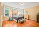 Bedroom features a four-poster bed, hardwood floors, natural light, and neutral paint at 10540 Byrum Woods Dr, Raleigh, NC 27613