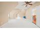 Bright bonus room featuring neutral paint, plush carpet, a ceiling fan, and an adjacent staircase at 10540 Byrum Woods Dr, Raleigh, NC 27613