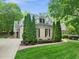 Charming home with manicured lawn, mature trees, and elegant brick and stone accents at 10540 Byrum Woods Dr, Raleigh, NC 27613