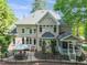 Brick home exterior featuring a back patio with outdoor dining, black metal fence, and well-manicured landscaping at 10540 Byrum Woods Dr, Raleigh, NC 27613