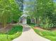 Beautiful home with an expansive driveway, lush lawn, and mature trees at 10540 Byrum Woods Dr, Raleigh, NC 27613