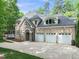 Exterior of a brick home with a large driveway and three-car garage at 10540 Byrum Woods Dr, Raleigh, NC 27613