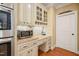 Kitchen desk area with marble countertops, white cabinets, and modern appliances at 10540 Byrum Woods Dr, Raleigh, NC 27613