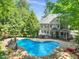 Aerial view of backyard pool with slide, next to a brick house with a screened porch and outdoor seating at 10540 Byrum Woods Dr, Raleigh, NC 27613