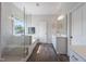 A bright bathroom boasts a soaking tub, glass shower, double vanity, and a window offering natural light at 109 Obsidian Dr, Holly Springs, NC 27540