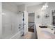 A bathroom with double sinks, a shower-tub combo, and a doorway leading to an upper floor at 109 Obsidian Dr, Holly Springs, NC 27540