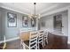 Bright and open dining room featuring a large wooden table, statement lighting, and stylish wall decor at 109 Obsidian Dr, Holly Springs, NC 27540