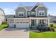 Charming two-story home with a well-maintained lawn, two car garage, and inviting front porch at 109 Obsidian Dr, Holly Springs, NC 27540