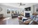 Bright living room with fireplace, large windows, hardwood floors, and comfortable leather seating at 109 Obsidian Dr, Holly Springs, NC 27540