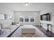 Inviting living room featuring a plush sofa, large ottoman, and expansive windows for lots of natural light at 109 Obsidian Dr, Holly Springs, NC 27540