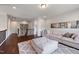 Spacious living room with hardwood floors, white couch, and large ottoman leading into a hallway at 109 Obsidian Dr, Holly Springs, NC 27540
