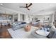 Open-concept living room with views to kitchen and dining area, featuring hardwood floors and ceiling fan at 109 Obsidian Dr, Holly Springs, NC 27540
