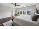 Bright main bedroom with tray ceiling, large windows overlooking the back yard, and hardwood floors at 109 Obsidian Dr, Holly Springs, NC 27540