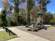 Community playground with multiple slides and a bench in a leafy neighborhood at 109 Obsidian Dr, Holly Springs, NC 27540