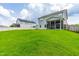 Expansive back yard with lush green grass, screened in porch, and fire pit area at 1104 Arden Trace Ct, Fuquay Varina, NC 27526