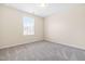 Empty carpeted bedroom with neutral walls and a window providing natural light at 1104 Arden Trace Ct, Fuquay Varina, NC 27526