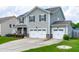 Two-story home with gray siding, black shutters, solar panels, well-manicured lawn, and a two car garage at 1104 Arden Trace Ct, Fuquay Varina, NC 27526