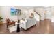 Open concept living room has hardwood floors, a leather chair, a sofa, and a television on the wall at 1104 Arden Trace Ct, Fuquay Varina, NC 27526